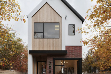 Mid-sized danish white two-story brick exterior home photo in Calgary with a shingle roof and a black roof