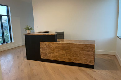 Ejemplo de despacho actual grande con paredes beige, suelo de madera clara, escritorio empotrado y suelo beige