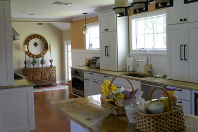 Example of a large classic galley medium tone wood floor eat-in kitchen design in New York with an undermount sink, shaker cabinets, white cabinets, stainless steel appliances, an island and soapstone countertops