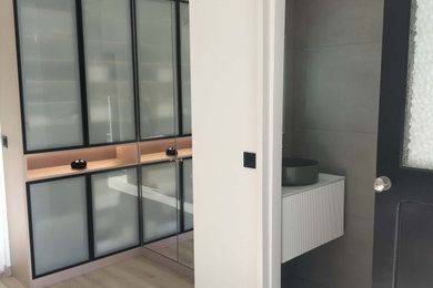 Réalisation d'une chambre d'amis beige et blanche design de taille moyenne avec un mur blanc, un sol en vinyl, un sol beige et dressing.
