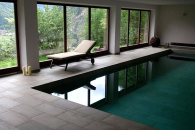 This is an example of a mid-sized transitional indoor rectangular lap pool in Atlanta with concrete pavers.