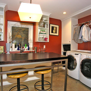 グランドラピッズの大きいトランジショナルスタイルのおしゃれな家事室 (赤い壁、左右配置の洗濯機・乾燥機) の写真