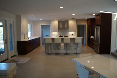 Example of a mid-sized minimalist u-shaped ceramic tile and beige floor eat-in kitchen design in Miami with flat-panel cabinets, white cabinets, granite countertops, white backsplash, subway tile backsplash, stainless steel appliances and an island