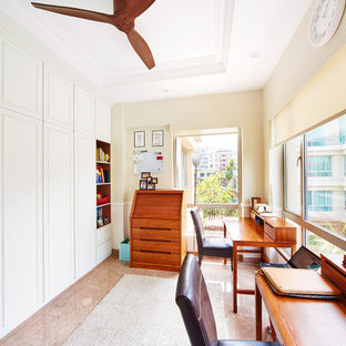 Photo of a mid-sized traditional study room in Singapore with beige walls, marble floors and a freestanding desk.