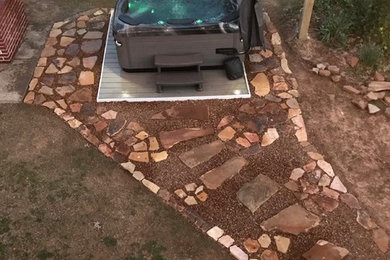 Example of a mid-sized transitional backyard stone and rectangular hot tub design in Other