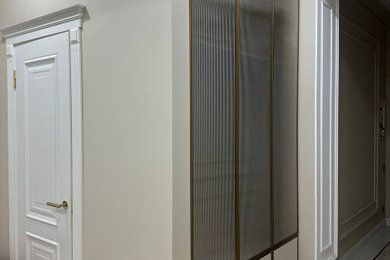 На фото: узкая прихожая среднего размера: освещение в современном стиле с бежевыми стенами, полом из керамической плитки, стеклянной входной дверью и бежевым полом с