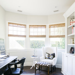 Bild på ett maritimt hemmabibliotek, med beige väggar, mörkt trägolv, ett fristående skrivbord och brunt golv