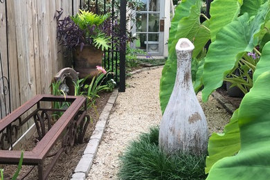 Photo of a mid-sized tropical partial sun side yard gravel garden path in New Orleans for summer.