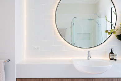 Inspiration for a mid-sized contemporary 3/4 bathroom in Melbourne with medium wood cabinets, white tile, porcelain tile, white walls, porcelain floors, engineered quartz benchtops, beige floor, a hinged shower door and white benchtops.