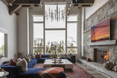Living room - rustic open concept dark wood floor and brown floor living room idea in Other with white walls, a standard fireplace, a stone fireplace and a wall-mounted tv