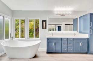 Bathroom - large modern master multicolored tile and porcelain tile vinyl floor, beige floor, double-sink and vaulted ceiling bathroom idea in Orange County with blue cabinets, gray walls, an undermount sink, quartz countertops, white countertops, a niche, a built-in vanity, shaker cabinets and a hinged shower door