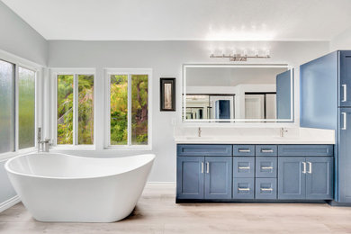 Bathroom - large modern master multicolored tile and porcelain tile vinyl floor, beige floor, double-sink and vaulted ceiling bathroom idea in Orange County with blue cabinets, gray walls, an undermount sink, quartz countertops, white countertops, a niche, a built-in vanity, shaker cabinets and a hinged shower door