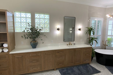 Example of a master single-sink freestanding bathtub design in Jacksonville with shaker cabinets and light wood cabinets