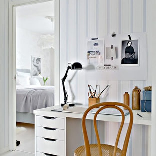 Inredning av ett minimalistiskt hemmabibliotek, med flerfärgade väggar, ljust trägolv och ett fristående skrivbord