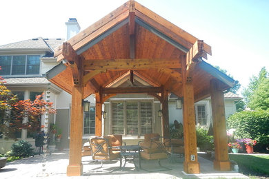 Patio - small craftsman backyard concrete paver patio idea in Kansas City with a roof extension