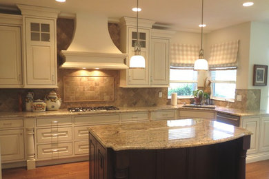 Example of a mid-sized classic u-shaped light wood floor eat-in kitchen design in Denver with an undermount sink, beaded inset cabinets, white cabinets, granite countertops, beige backsplash, stone tile backsplash, stainless steel appliances and an island
