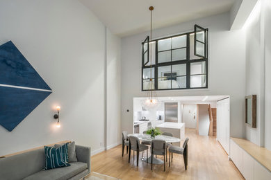 Inspiration for a mid-sized modern light wood floor and beige floor great room remodel in New York with gray walls