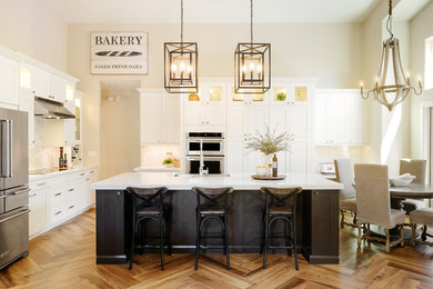 Large farmhouse l-shaped medium tone wood floor open concept kitchen photo in Phoenix with a farmhouse sink, shaker cabinets, white cabinets, quartz countertops, gray backsplash, mosaic tile backsplash, stainless steel appliances and an island