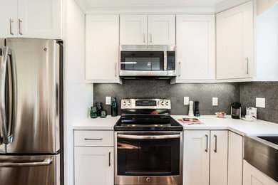 Transitional single-wall laminate floor eat-in kitchen photo in Orange County with a double-bowl sink, recessed-panel cabinets, white cabinets, quartzite countertops, gray backsplash, glass tile backsplash, stainless steel appliances and an island
