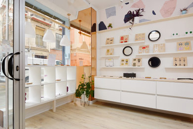 Imagen de entrada contemporánea pequeña con paredes blancas, suelo de madera clara y suelo beige