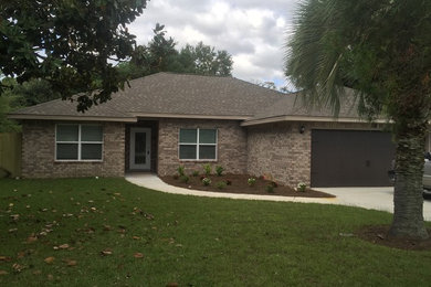 Mid-sized traditional one-story brick exterior home idea in Miami with a hip roof