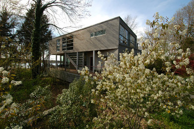 Design ideas for a mid-sized modern two-storey grey exterior with wood siding.