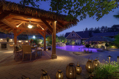 Patio kitchen - large tropical backyard patio kitchen idea in Toronto with a gazebo