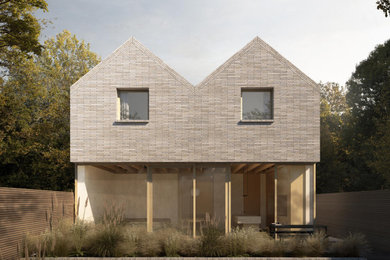 This is an example of a large and gey two floor brick and rear detached house in London with a pitched roof, a tiled roof and a grey roof.
