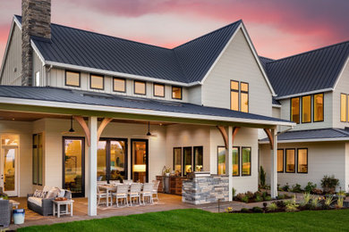 Example of a large farmhouse beige two-story wood house exterior design in Salt Lake City with a metal roof and a black roof