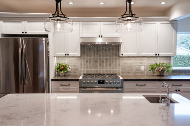 Eat-in kitchen - large craftsman l-shaped dark wood floor, brown floor and exposed beam eat-in kitchen idea in Vancouver with an undermount sink, recessed-panel cabinets, white cabinets, quartzite countertops, gray backsplash, ceramic backsplash, stainless steel appliances, an island and multicolored countertops