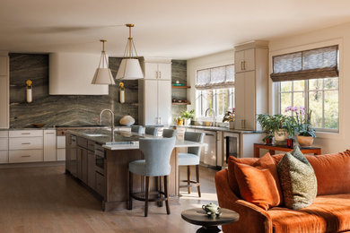 Inspiration for a large transitional u-shaped medium tone wood floor open concept kitchen remodel in New York with an undermount sink, shaker cabinets, beige cabinets, quartzite countertops, green backsplash, stone slab backsplash, stainless steel appliances, an island and green countertops