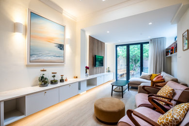 Kleines, Offenes Modernes Wohnzimmer ohne Kamin mit beiger Wandfarbe, braunem Holzboden, TV-Wand, braunem Boden und Wandpaneelen in London