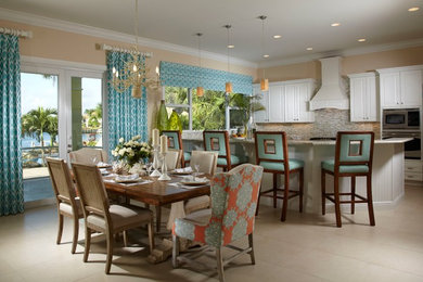 Inspiration for a mid-sized coastal l-shaped eat-in kitchen remodel in Miami with raised-panel cabinets, white cabinets, granite countertops, beige backsplash, stainless steel appliances and an island