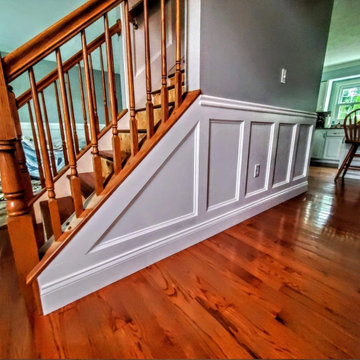 Hallway with custom wainscoting and hardwood flooring
