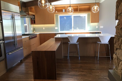 Example of a mid-sized minimalist medium tone wood floor kitchen design in Seattle with flat-panel cabinets, light wood cabinets, wood countertops, stainless steel appliances and two islands