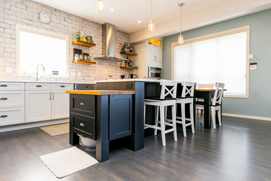 Eat-in kitchen - large industrial l-shaped dark wood floor eat-in kitchen idea in Calgary with shaker cabinets, white backsplash, two islands, white cabinets, marble countertops, an undermount sink, brick backsplash and stainless steel appliances