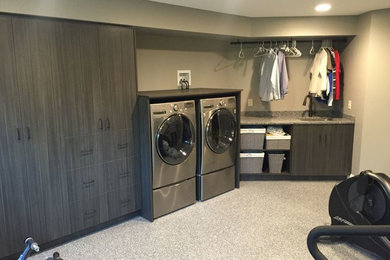 Large trendy single-wall utility room photo in Minneapolis with beige walls, an undermount sink, flat-panel cabinets, dark wood cabinets and a side-by-side washer/dryer
