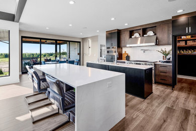 Huge trendy l-shaped medium tone wood floor and brown floor open concept kitchen photo in Other with an undermount sink, flat-panel cabinets, dark wood cabinets, quartz countertops, white backsplash, stainless steel appliances, two islands and white countertops