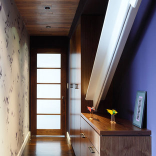 ニューヨークの片開きドアコンテンポラリースタイルのおしゃれな玄関ホール (紫の壁、濃色無垢フローリング、ガラスドア) の写真