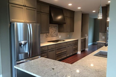 Example of a large transitional galley dark wood floor and brown floor eat-in kitchen design in Portland with an undermount sink, shaker cabinets, gray cabinets, granite countertops, white backsplash, subway tile backsplash, stainless steel appliances and a peninsula