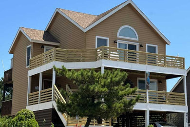 Inspiration for a large coastal brown three-story vinyl and clapboard exterior home remodel in Other with a shingle roof and a brown roof