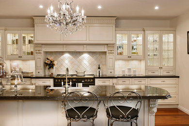 Enclosed kitchen - large traditional l-shaped medium tone wood floor enclosed kitchen idea in Los Angeles with white backsplash, flat-panel cabinets, medium tone wood cabinets, granite countertops, stainless steel appliances, a farmhouse sink, ceramic backsplash and an island