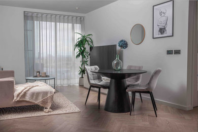 Medium sized scandinavian open plan living room in London with white walls, medium hardwood flooring, no fireplace and a freestanding tv.
