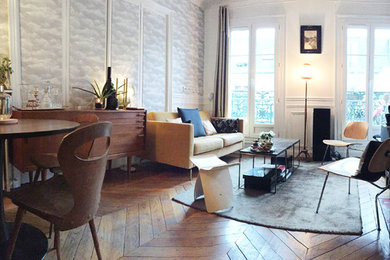 Photo of a mid-sized transitional open concept living room in Paris with white walls, light hardwood floors, a wall-mounted tv and brown floor.