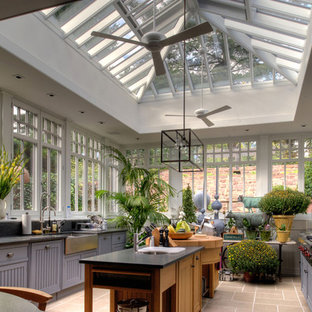 Foto de cocina de estilo de casa de campo, cerrada, con fregadero sobremueble, electrodomésticos de acero inoxidable y puertas de armario azules