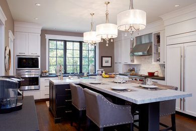 Inspiration for a mid-sized transitional dark wood floor enclosed kitchen remodel in Philadelphia with an undermount sink, recessed-panel cabinets, white cabinets, marble countertops, white backsplash, ceramic backsplash, paneled appliances and two islands