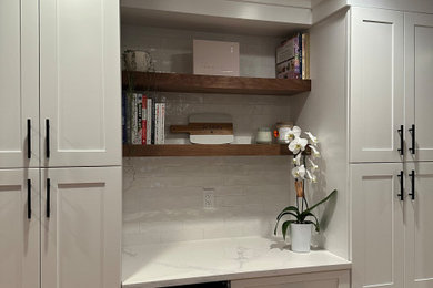 Inspiration for a home bar remodel in New York with floating shelves, white cabinets, white backsplash, cement tile backsplash and white countertops
