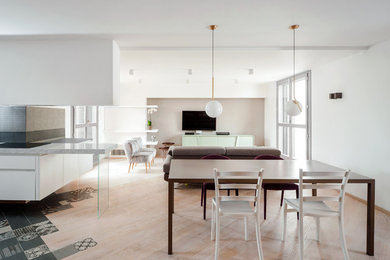 Photo of a large contemporary open plan dining in Rome with white walls and light hardwood floors.