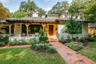 Photo of a mid-sized mediterranean one-storey brick white house exterior in Dallas with a gable roof and a tile roof.