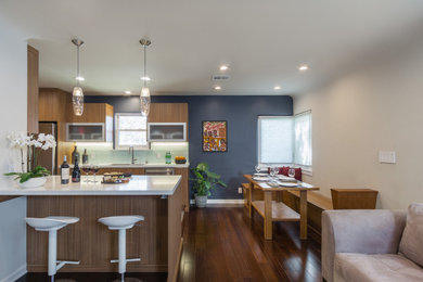 Design ideas for a mid-sized midcentury galley eat-in kitchen in Los Angeles with an undermount sink, flat-panel cabinets, medium wood cabinets, quartz benchtops, white splashback, glass tile splashback, stainless steel appliances, medium hardwood floors, a peninsula, brown floor and white benchtop.